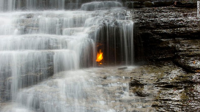 A golden flame flickers behind a small waterfall in the Shale Creek Preserve section of Chestnut Ridge Park. A geological fault allows methane gas to escape to the surface, where at some point a visitor set it alight. 